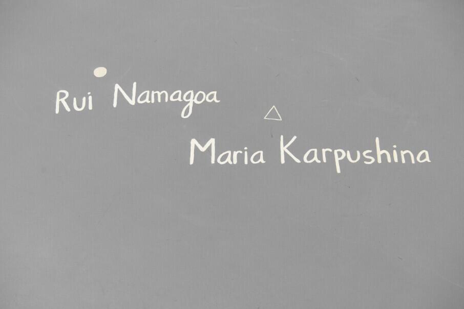 Handwritten text on a gray background reading "Rui Namágoa" with a small triangle symbol, and "Maria Karpushina" below it, appearing to be names or references within an atlas reconstruction project.
